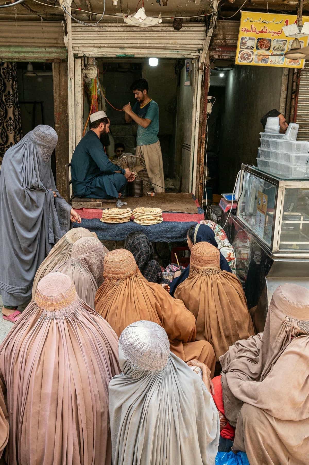 Những người phụ nữ tị nạn Afghanistan chờ bánh mì miễn phí